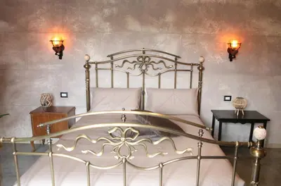 a bedroom with a metal bed with white pillows at Roma Imperial Suites in Rome