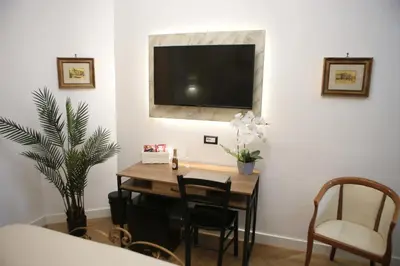 a dining room with a table and a television on a wall at Roma Imperial Suites in Rome