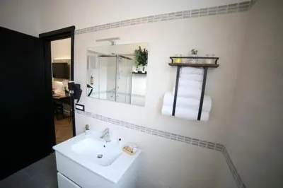 a white bathroom with a sink and a mirror at Roma Imperial Suites in Rome