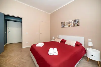 a bedroom with a red bed with two white towels at Domus Pietrae in Rome