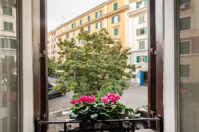 a window with pink flowers on a balcony at Domus Pietrae in Rome