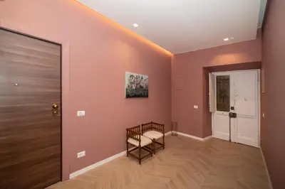 a hallway with pink walls and a door at Domus Pietrae in Rome