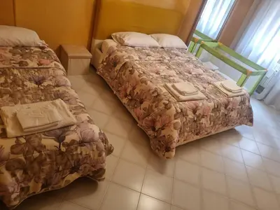 a bedroom with two beds and a tiled floor at Appartamento Antico AMOR in Rome