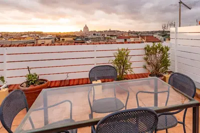 a table and chairs on a balcony with a view at Skyline Penthouse with Private Rooftop in Rome