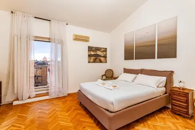 a bedroom with a large bed and a window at Skyline Penthouse with Private Rooftop in Rome