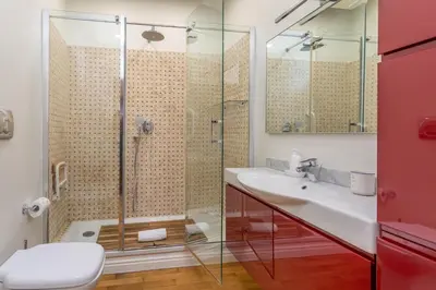 a bathroom with a glass shower and a sink at Skyline Penthouse with Private Rooftop in Rome