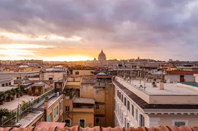 a cityscape of a city with a sunset in the background at Skyline Penthouse with Private Rooftop in Rome
