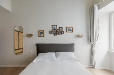 a bedroom with a bed and some pictures on the wall at Corso Caesar Suites in Rome
