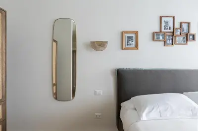 a bedroom with a mirror next to a bed at Corso Caesar Suites in Rome