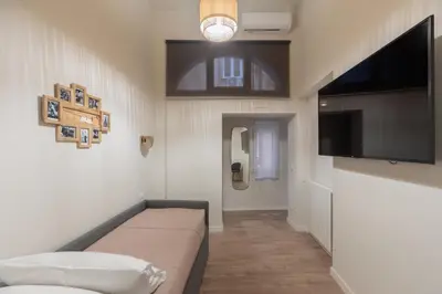 a living room with a couch and a flat screen tv at Corso Caesar Suites in Rome
