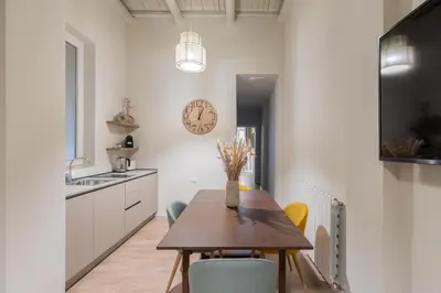 a kitchen with a table and chairs and a clock on the wall at Corso Caesar Suites in Rome