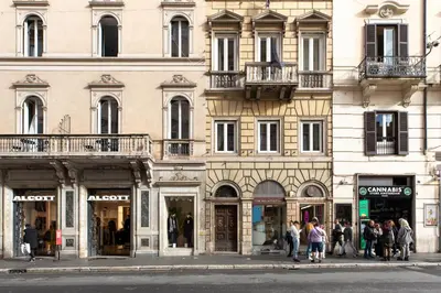 a group of people walking on a street in front of a building at Corso Caesar Suites in Rome