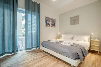 a bedroom with a bed with blue curtains and a window at Emily Valles Apartment Saint Peter's in Rome