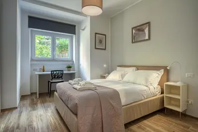 a bedroom with a bed and a desk and a window at Emily Valles Apartment Saint Peter's in Rome
