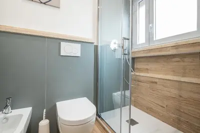 a bathroom with a toilet and a glass shower at Emily Valles Apartment Saint Peter's in Rome