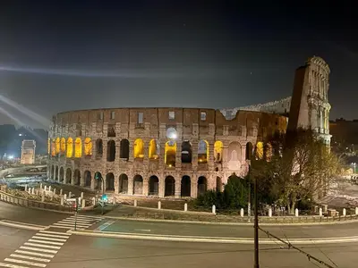 a large building with a clock tower at night at Colosseum Luxury Apartment in Rome