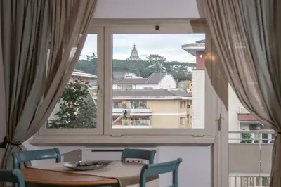 a table and chairs in a room with a large window at San Peter Terrace View in Rome