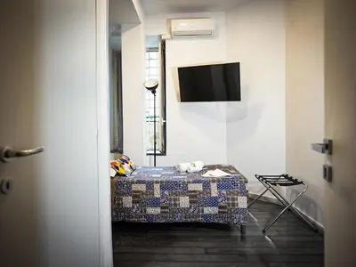 a room with a bed and a tv on a wall at Gate 40 Roma in Rome