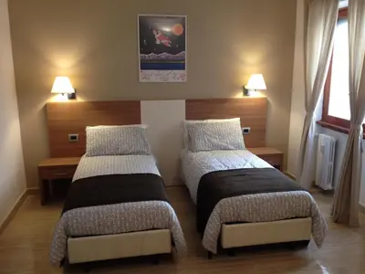 a bedroom with two beds and a chair in it at Trastevere's Friends in Rome