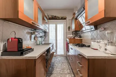 a kitchen with wooden cabinets and a red appliance at Appartamento Roma Centro in Rome