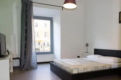 a bedroom with a bed and a large window at Lucky Domus Ottaviano in Rome