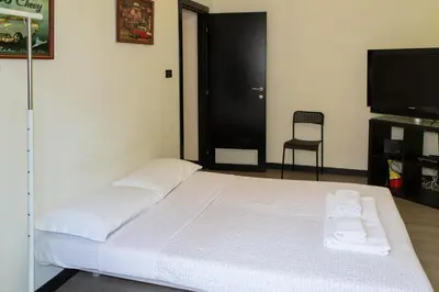 a bedroom with a bed and a television and a chair at Lucky Domus Ottaviano in Rome