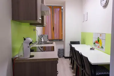 a kitchen with green and white counters and tables at Lucky Domus Ottaviano in Rome