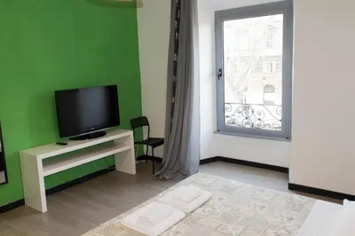a living room with a television and a green wall at Lucky Domus Ottaviano in Rome