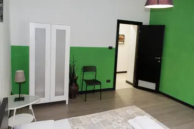 a green and white room with a bed and a chair at Lucky Domus Ottaviano in Rome