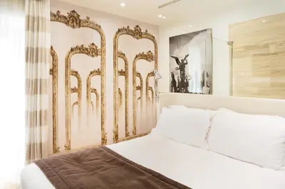 a bedroom with a white bed with gold accents at Via Del Corso Home Roma in Rome