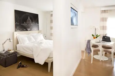 a white bedroom with a bed and a table at Via Del Corso Home Roma in Rome