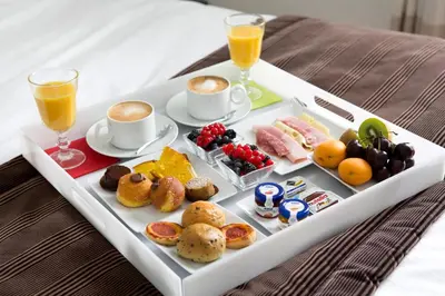a tray with breakfast foods and drinks on a bed at Via Del Corso Home Roma in Rome