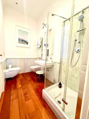 a bathroom with a glass shower and two sinks at Via Del Corso Home Roma in Rome