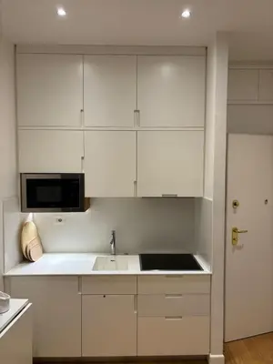 a white kitchen with a sink and a microwave at Via Del Corso Home Roma in Rome