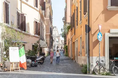 two people walking down a street in an alley at Elegant & Quiet Apartment next to Colosseo in Rome