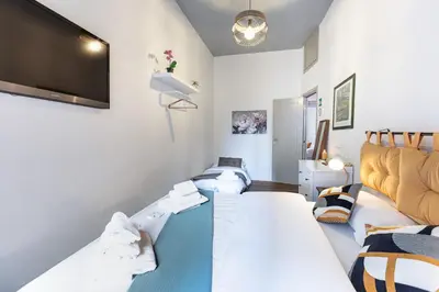 a room with three beds and a flat screen tv at La Locanda Bertani in Rome