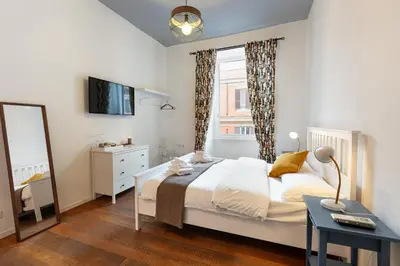a bedroom with a bed and a window and a mirror at La Locanda Bertani in Rome