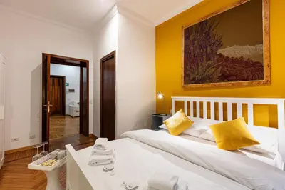 a bedroom with a white bed with yellow walls at Passeggiata al Vaticano in Rome
