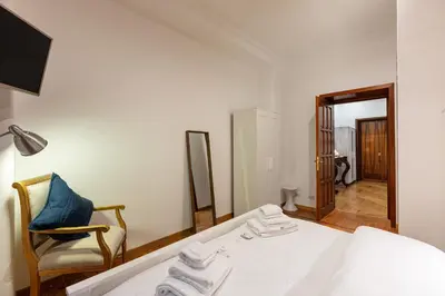 a bedroom with a bed and a chair and a mirror at Passeggiata al Vaticano in Rome