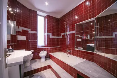 a red tiled bathroom with a tub and a toilet at Rome Aparts - Deluxe Apartment with 3 bedrooms at St Peter square in Rome