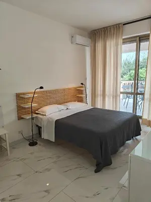 a bedroom with a bed and a large window at Appartamento Aurelio - Vaticano in Rome