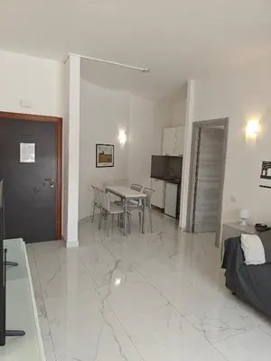 a living room with a table and a kitchen at Appartamento Aurelio - Vaticano in Rome