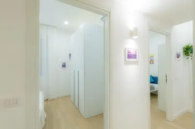 a hallway with white walls and a mirror at Contessa Elegance Inn in Rome