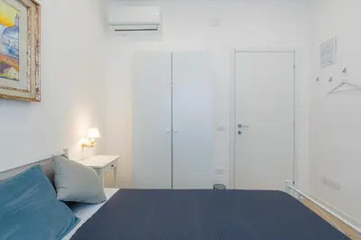 a white bedroom with a bed and a desk at Contessa Elegance Inn in Rome