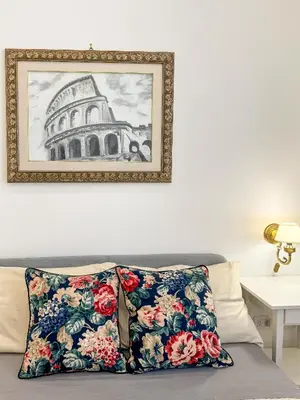 a painting hangs above a couch with two pillows at Contessa Elegance Inn in Rome