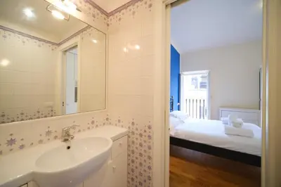 a bathroom with a sink and a mirror and a bed at Elisa's Trevi Fountain BuddyRent in Rome