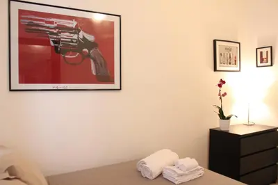 a bedroom with a picture of a gun on the wall at Maison Yassi Piazza del Popolo in Rome