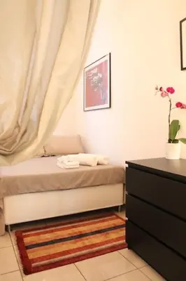 a bedroom with a bed and a dresser with a curtain at Maison Yassi Piazza del Popolo in Rome
