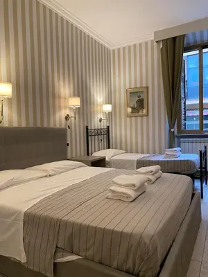 a hotel room with two beds and a window at Rome Orange Inn in Rome
