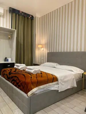 a bedroom with a bed with a tiger blanket on it at Rome Orange Inn in Rome